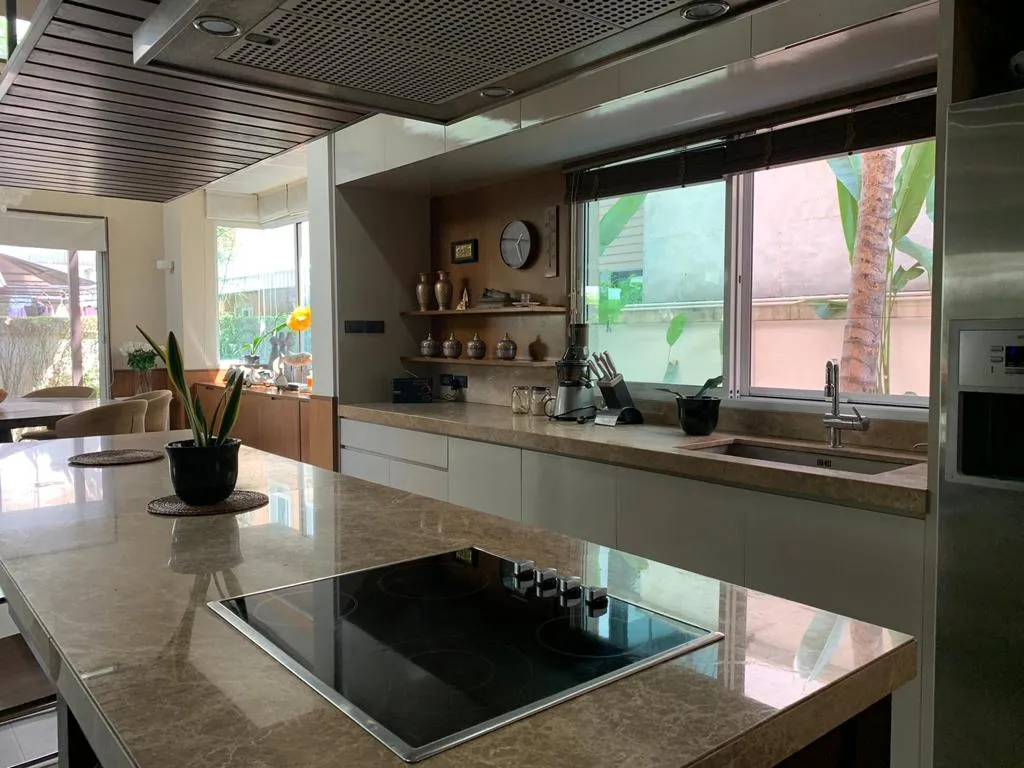 Stone-topped kitchen island with fitted cabinetry and a broad window
