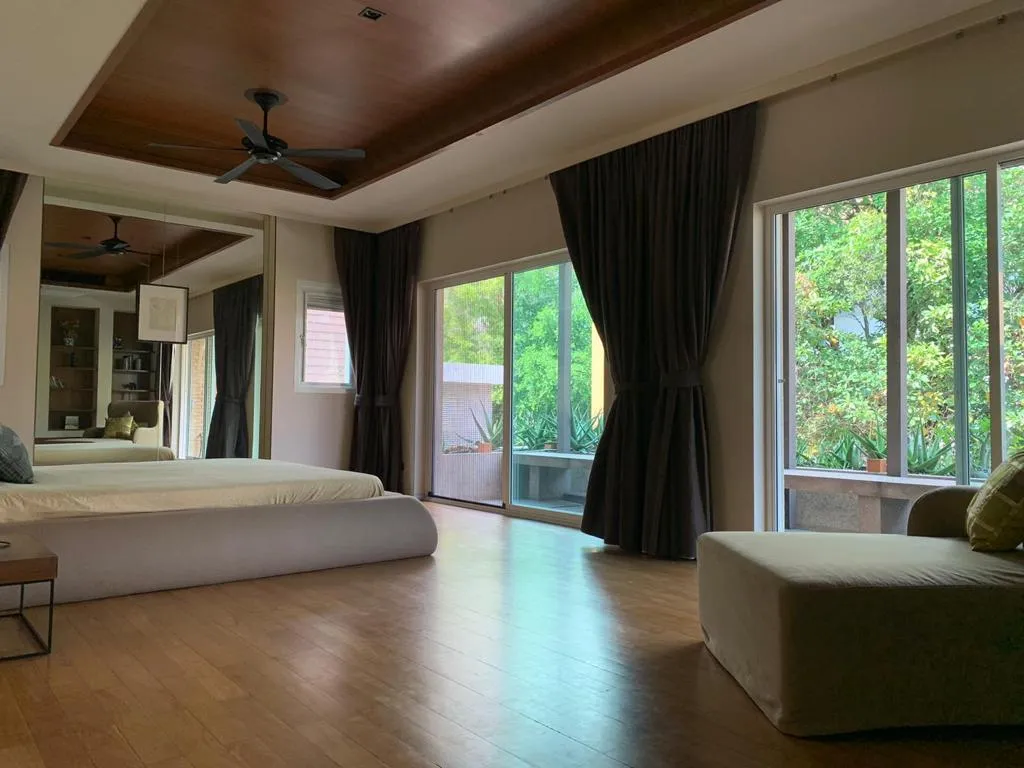 Main bedroom with timber flooring and doors to a planted terrace