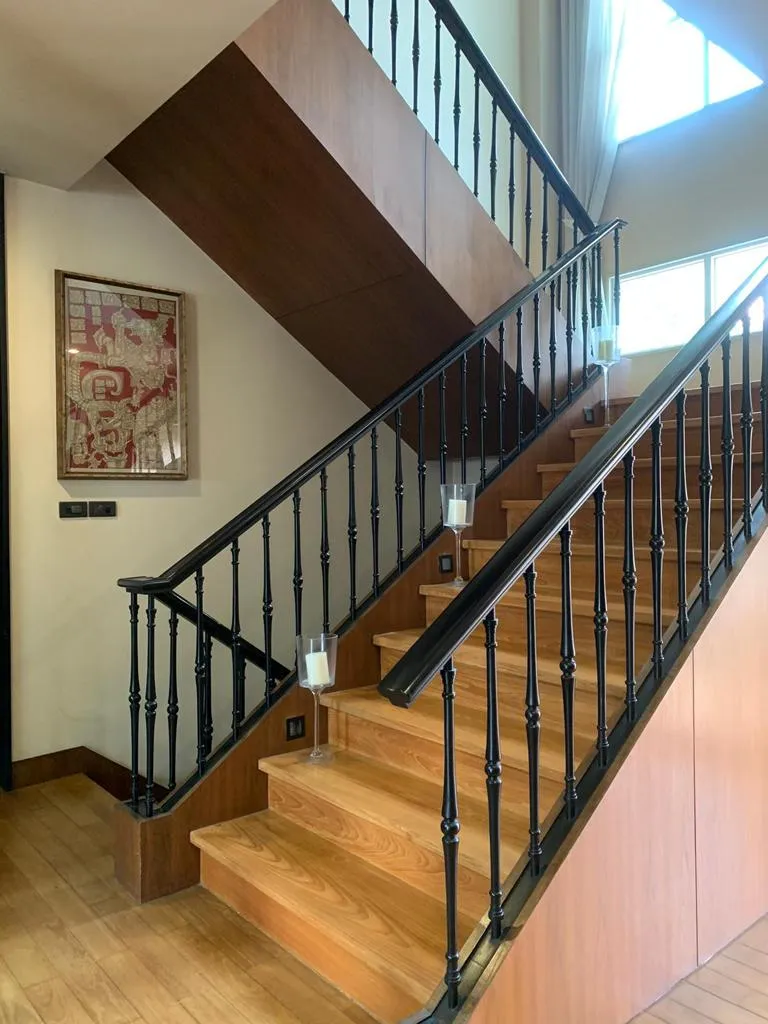 Timber staircase with dark balustrades and tall windows