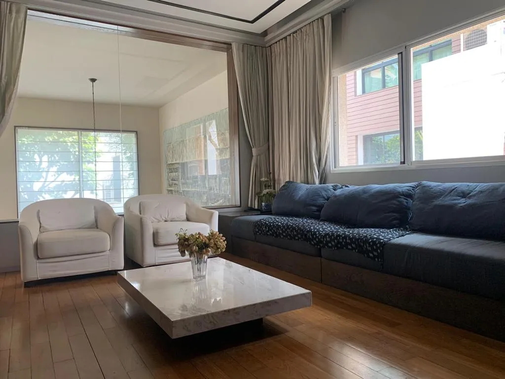 Upstairs sitting room with blue sofa and white armchairs