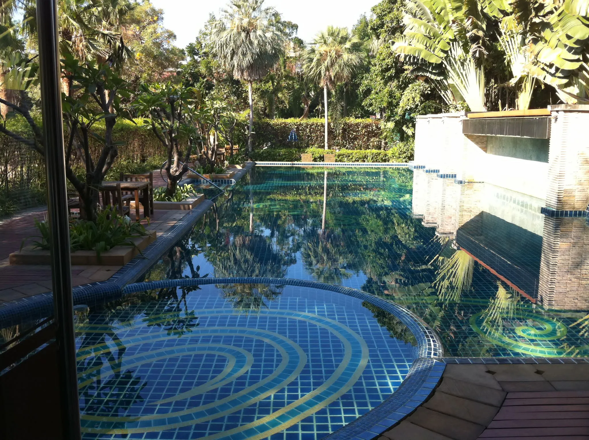 Shared village swimming pool surrounded by tropical planting