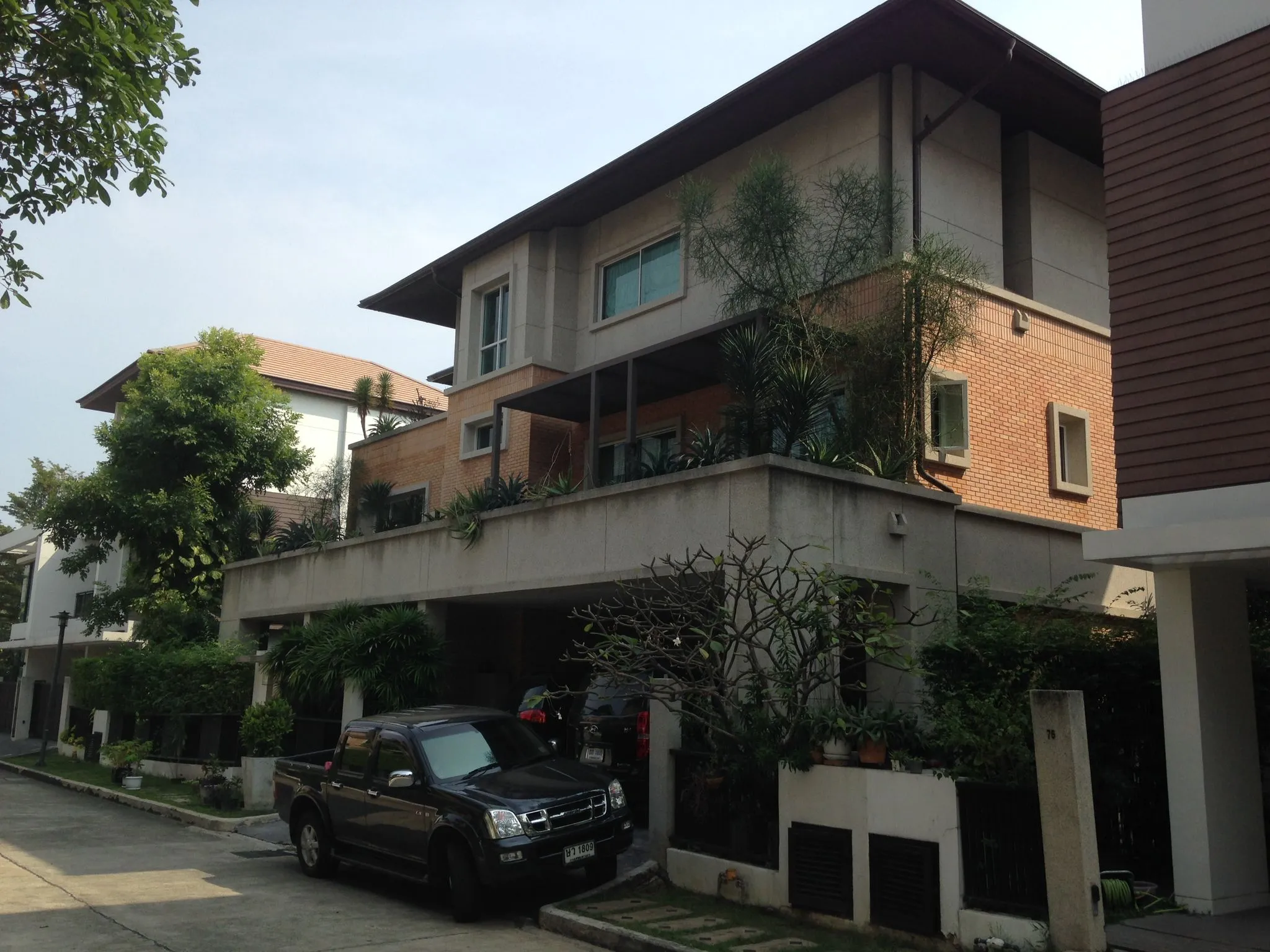 Brick and cream exterior framed by mature trees