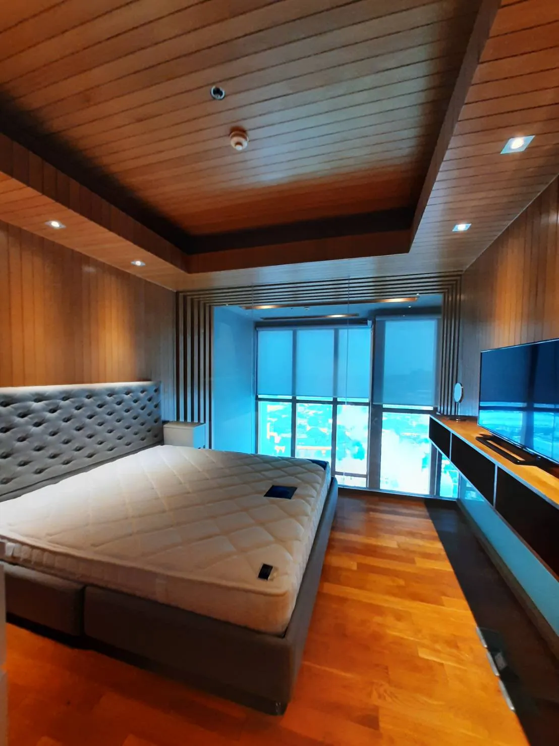 Bedroom with upholstered headboard and blue window shades