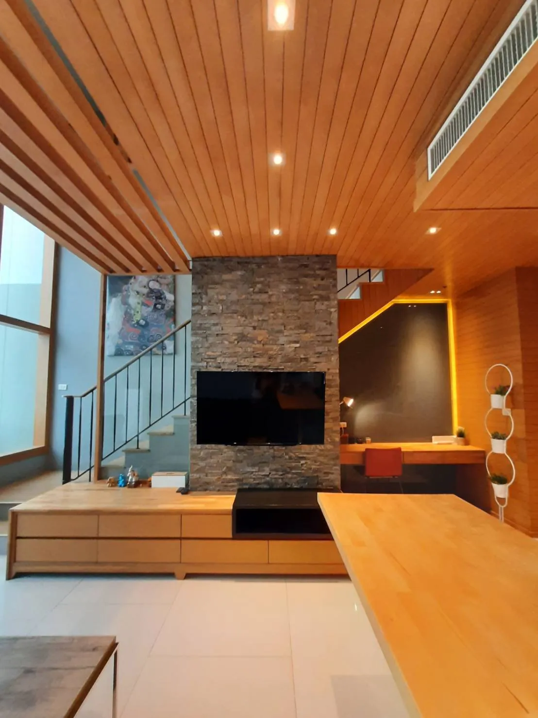 Stone television wall beside the duplex staircase