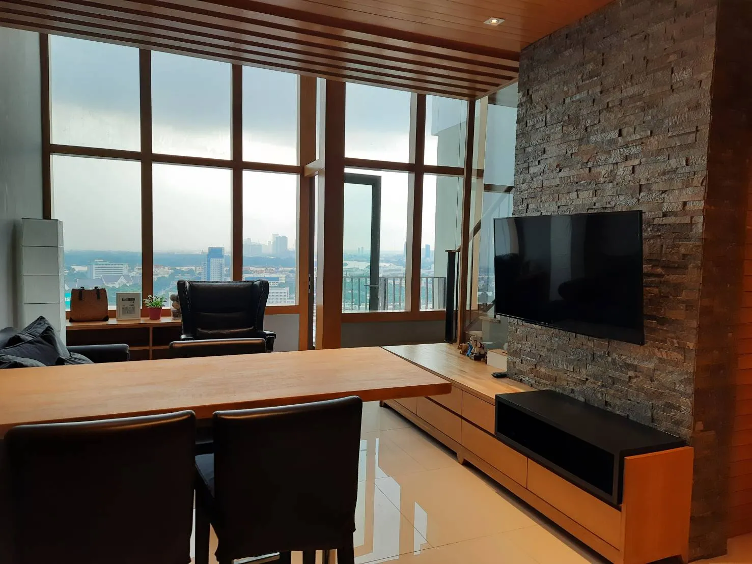 Bedroom workspace beside full-height city windows