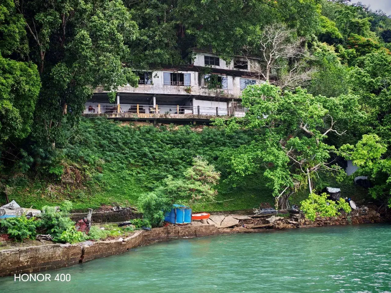 Existing accommodation building among dense waterfront trees