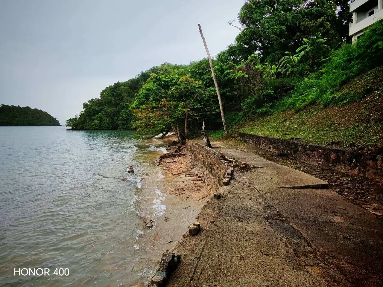 Narrow beach and concrete edge along the property