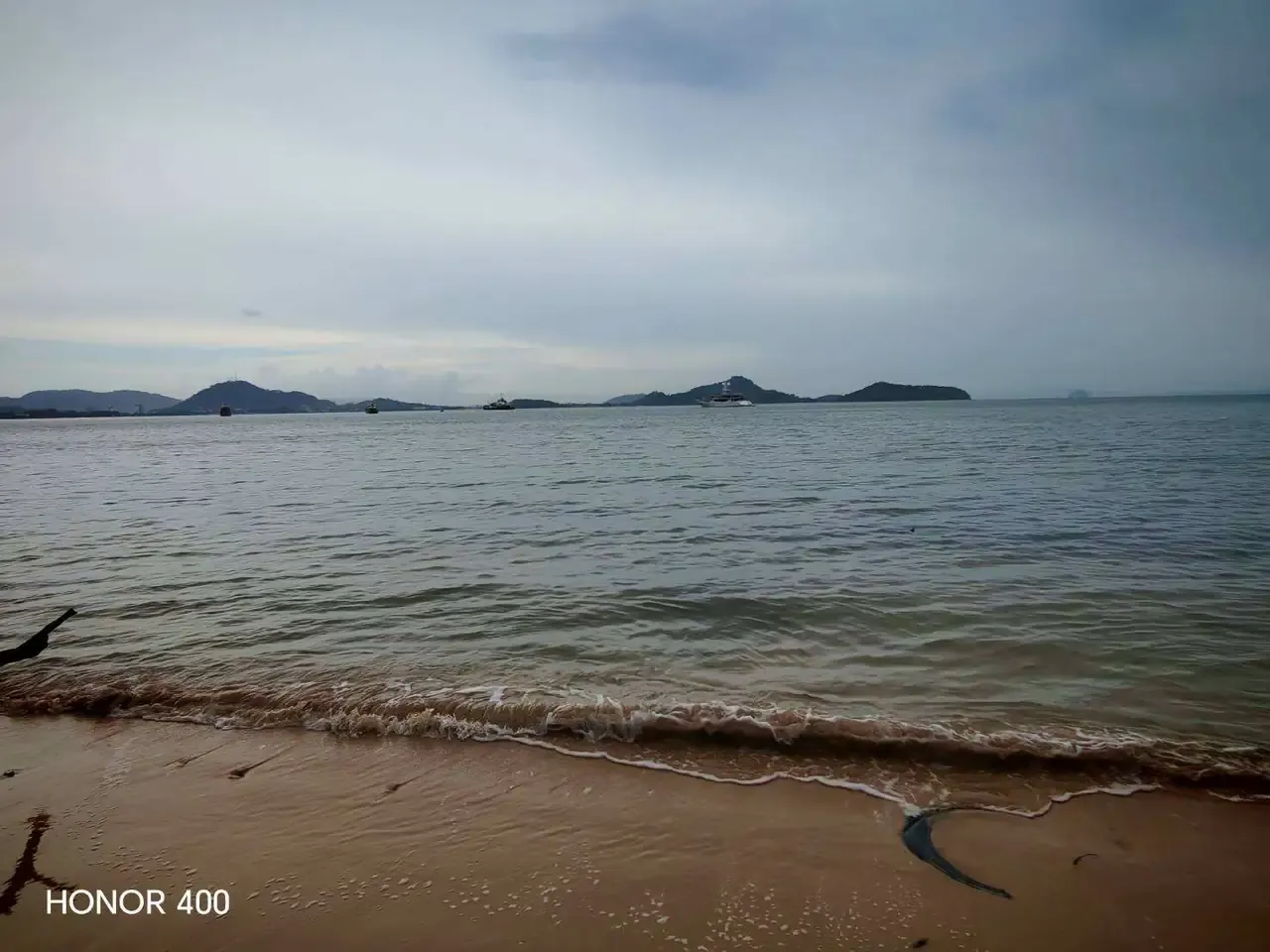 Sandy shoreline with neighbouring islands on the horizon