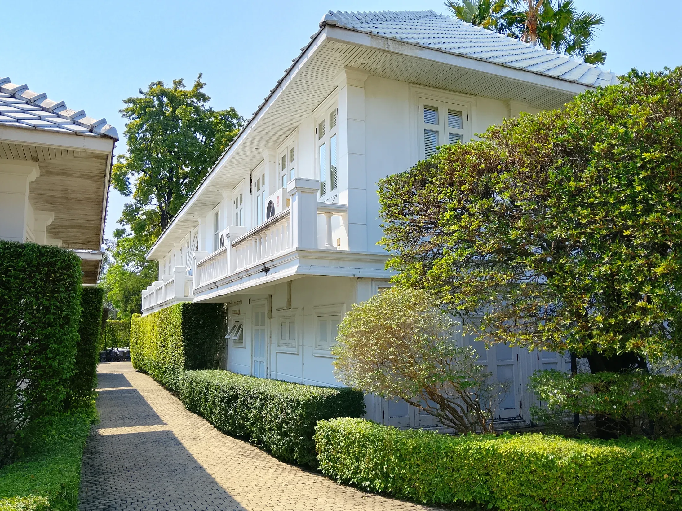 Two-storey guest residence beside a garden path