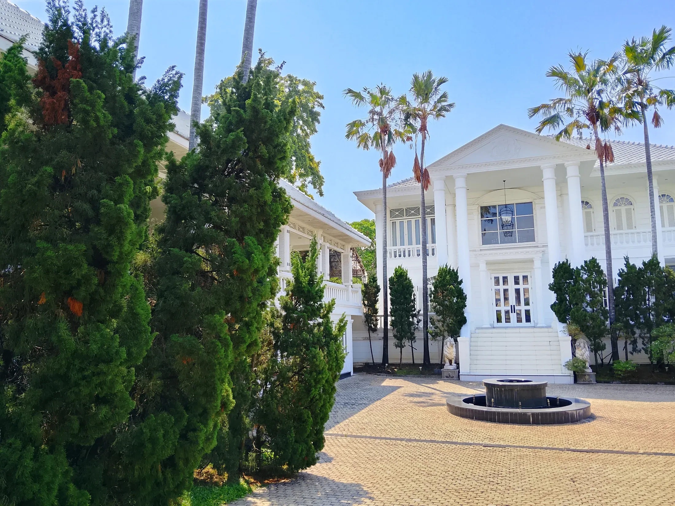 White riverside residence and palm-lined grounds at the Thai Ban estate
