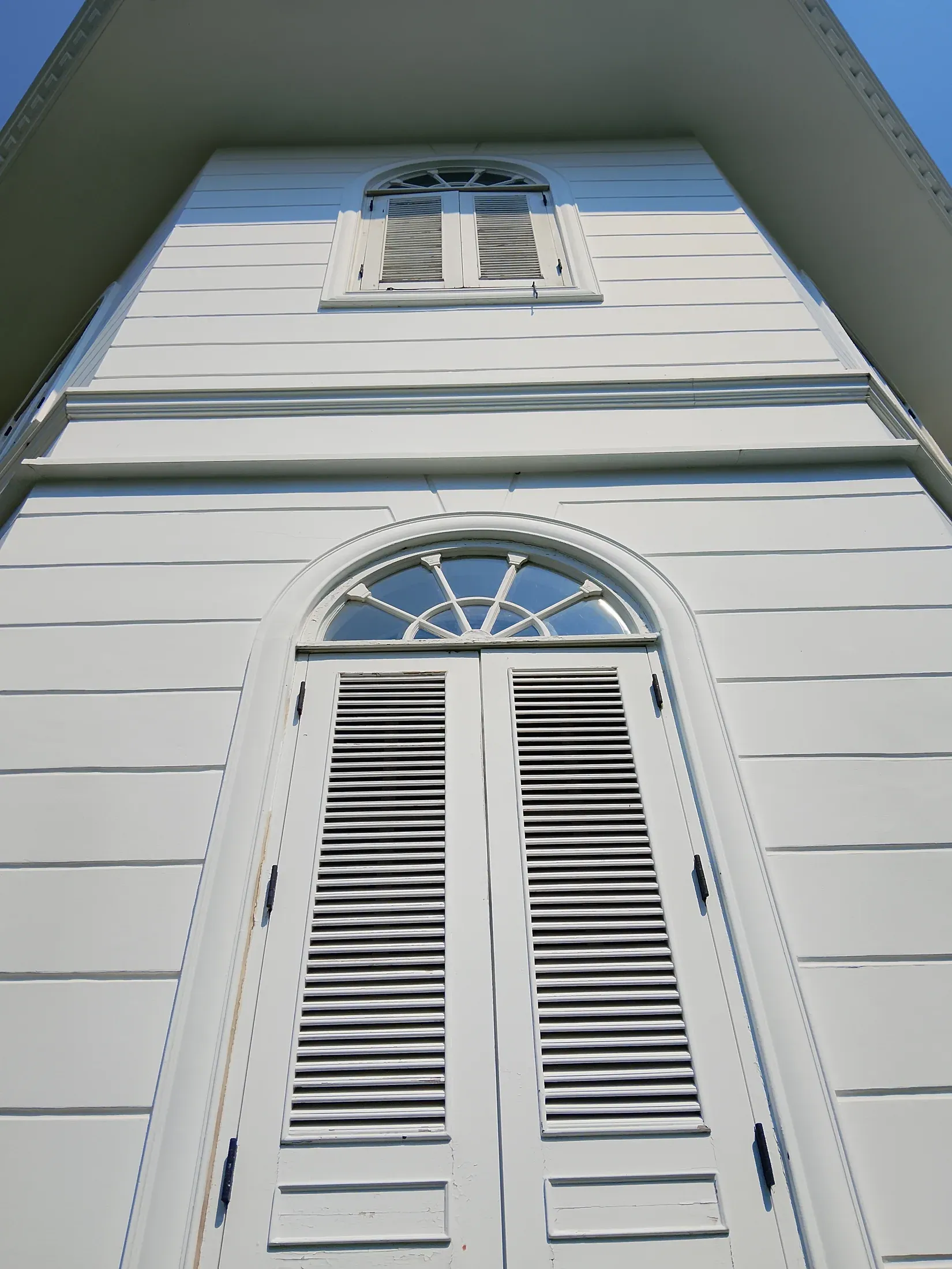 Arched window and shutters on the residence facade