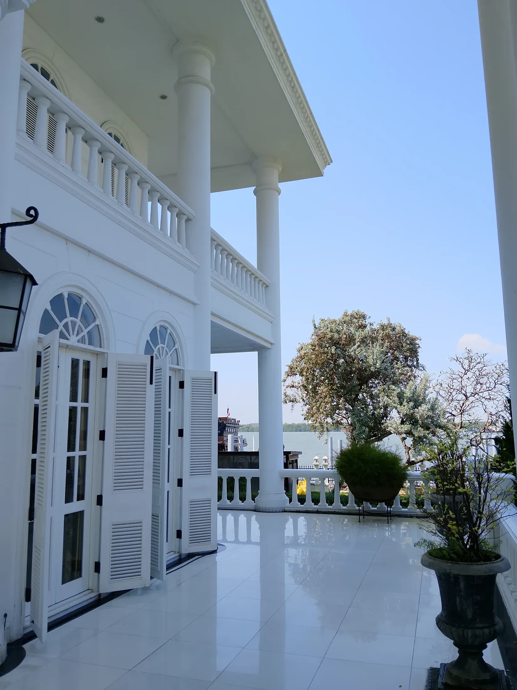 River-facing terrace framed by white columns